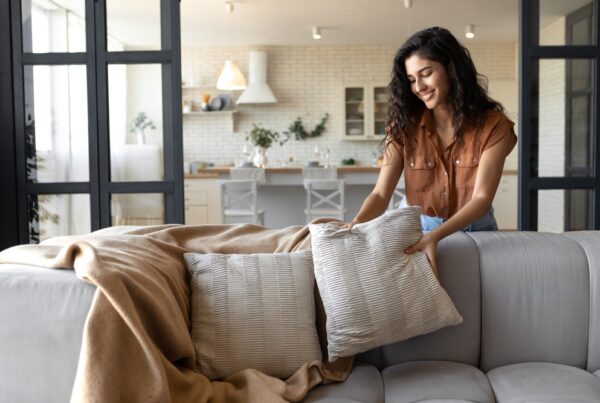 woman putting soft pillows over her couch